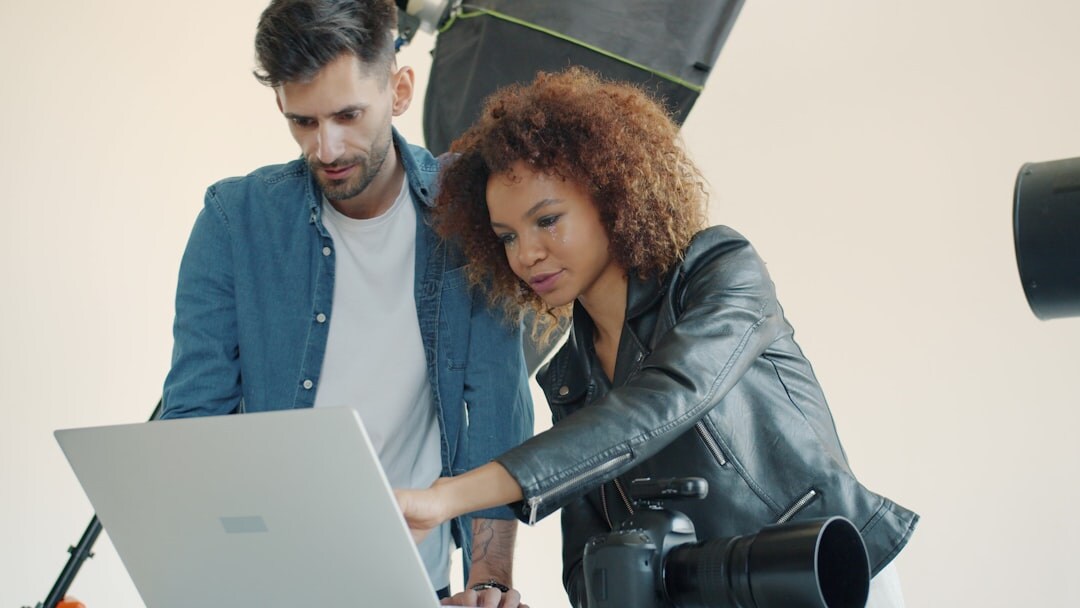 Two colleagues reviewing a video project together on a laptop