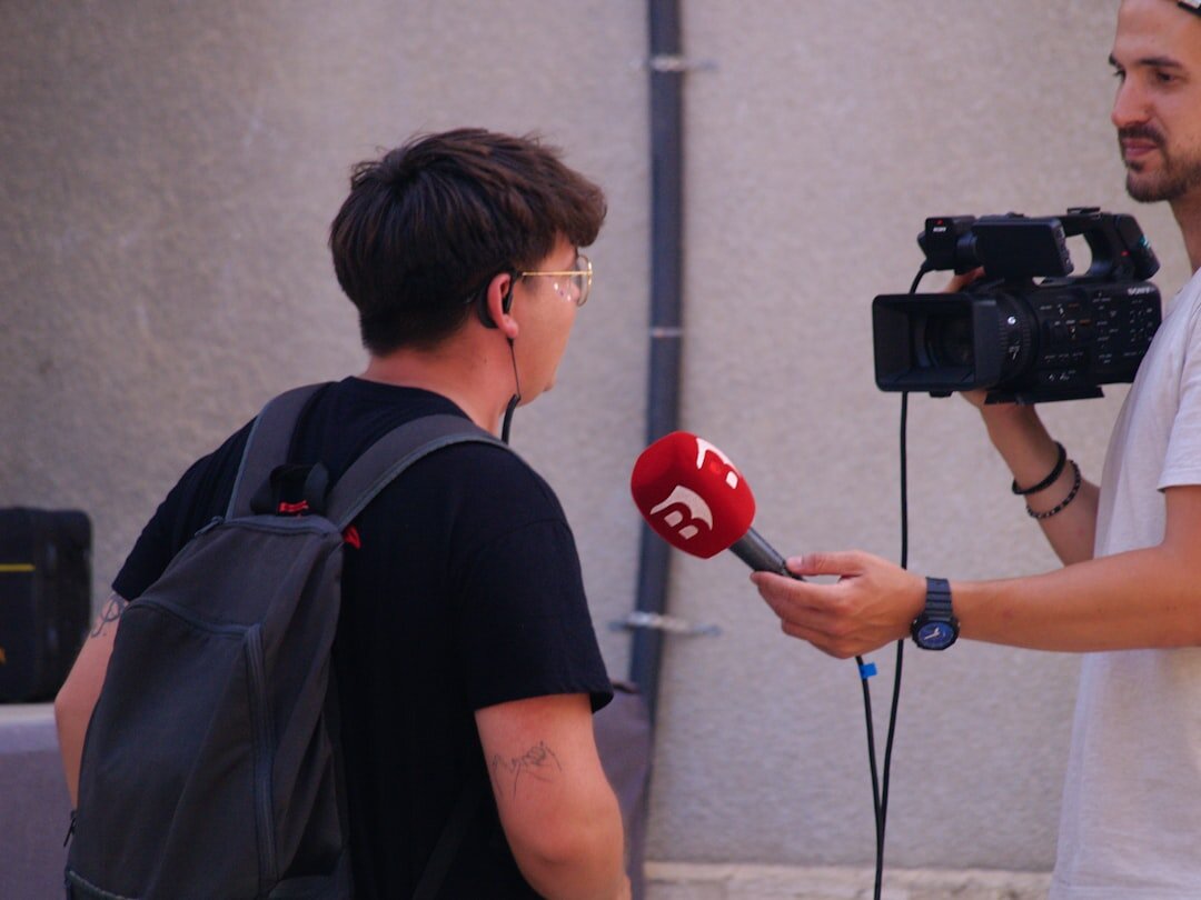 Journalist filming a reactive video report with a smartphone and microphone